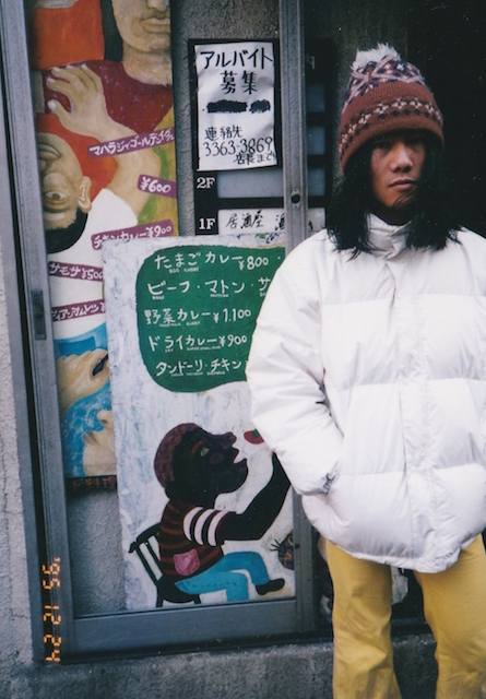 1995年のクリスマス・イブ、東京の西側にあった某インドカレー屋の前。ボンボン付きのニット帽＋レモン色のラッパズボンというファンシーな出で立ちで。こんな格好で東東京の町を歩けば大人でもカツアゲされます間違いなく